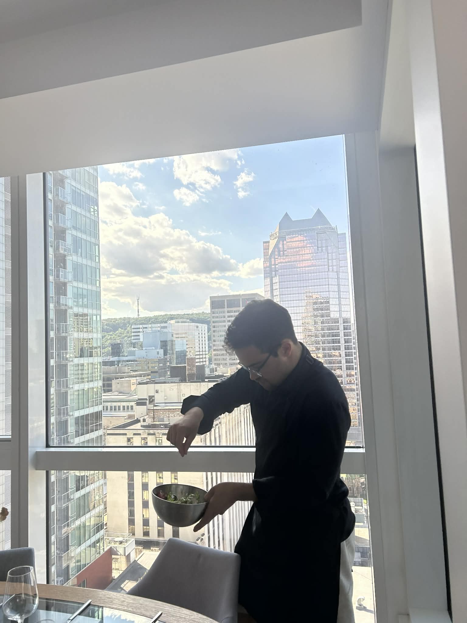 Chef Neil seasoning a dish while overlooking the city