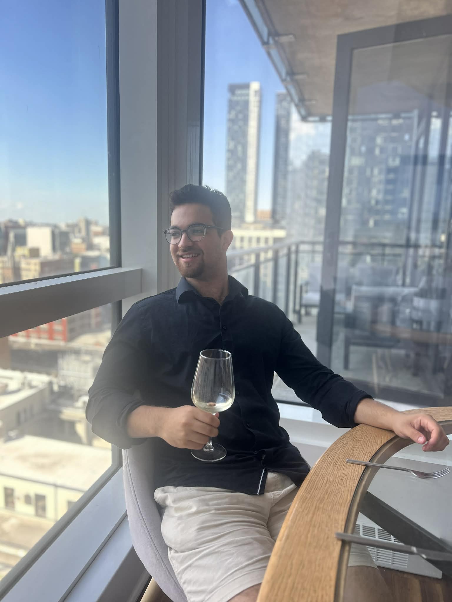 Chef Neil smiling, holding a glass of wine