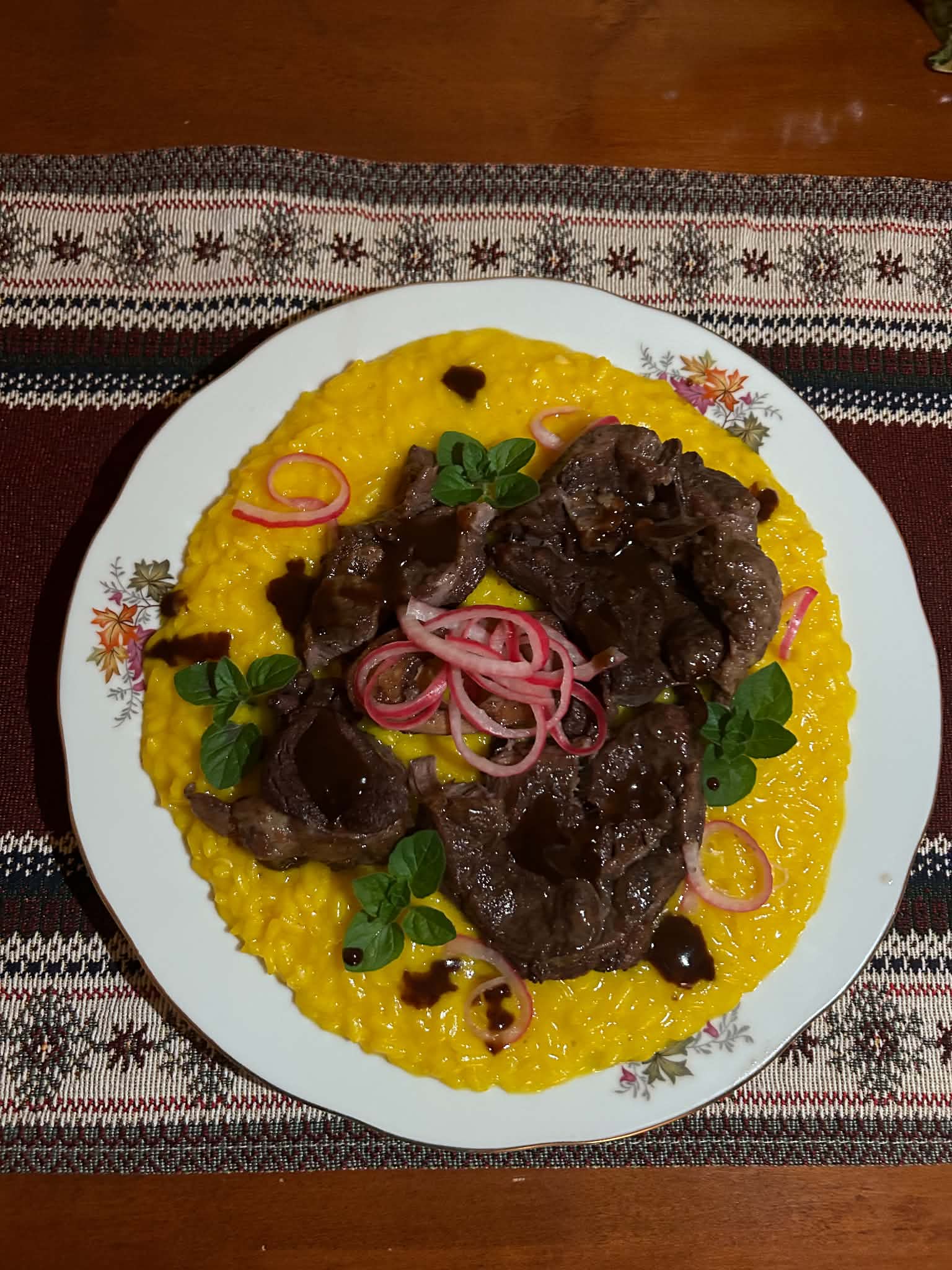 Saffron risotto topped with sliced braised beef shank